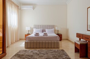 A neatly arranged bedroom with a large bed, bedside tables, a wooden dresser, and a fluffy rug. - Vesta - Luxury APT - 3BR - New Cairo IV (New Cairo)