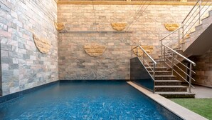 Una piscina con paredes de piedra y una escalera.