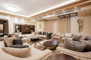 A spacious living room with a sofa set, a coffee table, and a TV. - Vesta - Luxury Villa - 6BR - New Cairo (New Cairo)