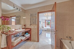 Ein modernes Badezimmer mit Waschtisch, Spiegel, Handtuchhalter und einer Duschkabine.