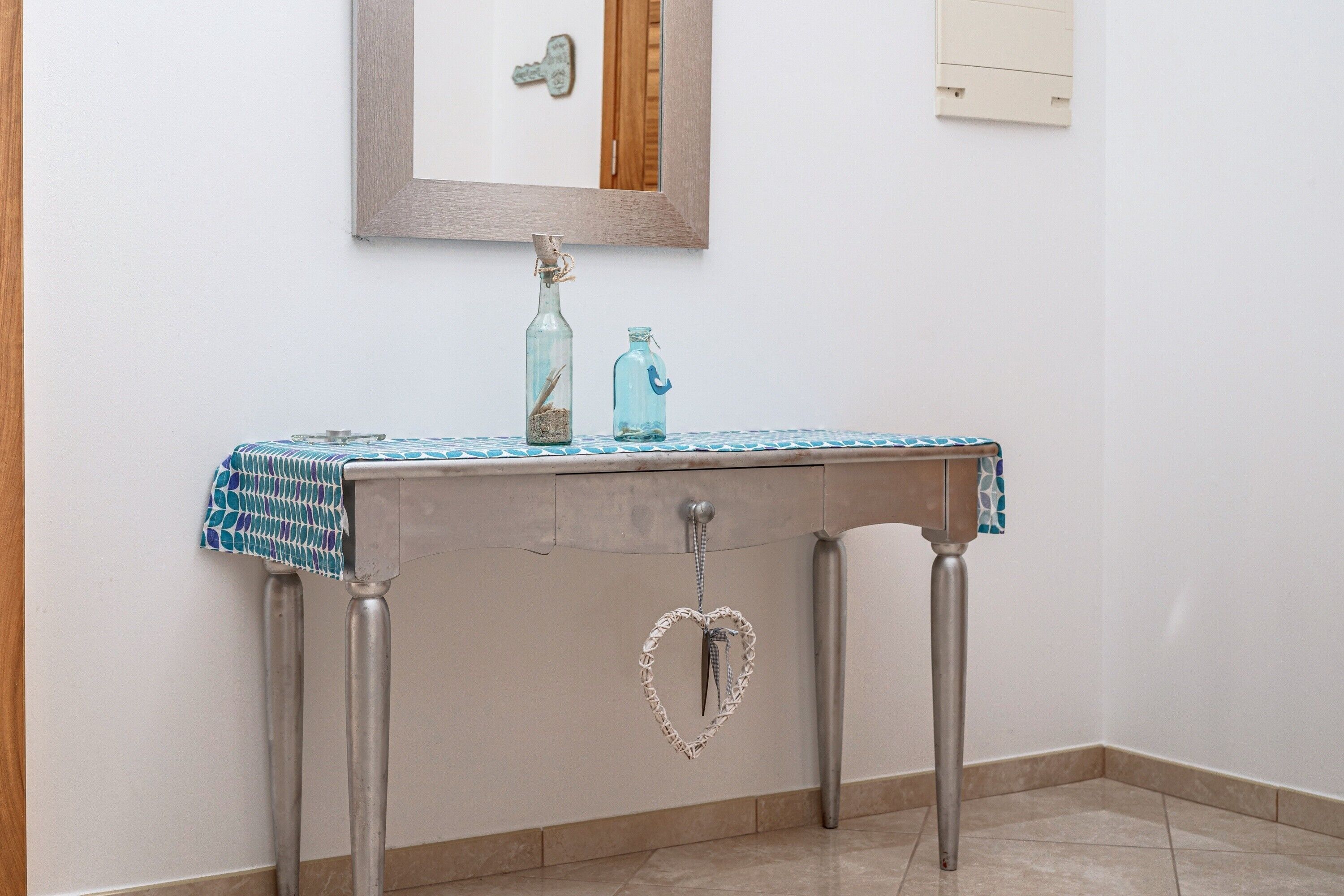 Une salle de bain avec un lavabo, un miroir et un porte-serviettes.