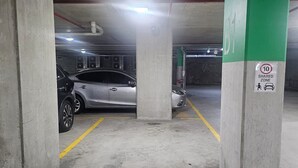 A parking garage with concrete pillars, yellow parking lines, and a shared zone sign. - Metawise BnB 2BR Hillsdale Family Stay Sleeps 6 (Sydney)