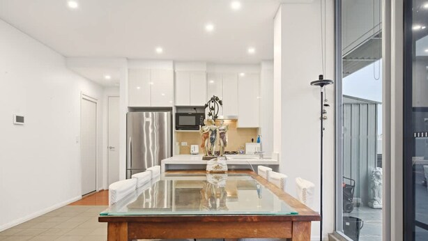 A modern kitchen with white cabinets, stainless steel appliances, and a glass dining table. - Metawise BnB Bright Open 2BR Arncliffe Sleeps 6 (Sydney)