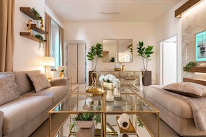A modern living room with a glass coffee table, two sofas, and decorative plants. - Roma Elegante 3 Bedrooms With 5 Star Comfort in Stylish Prati Neighborhood (Rome)