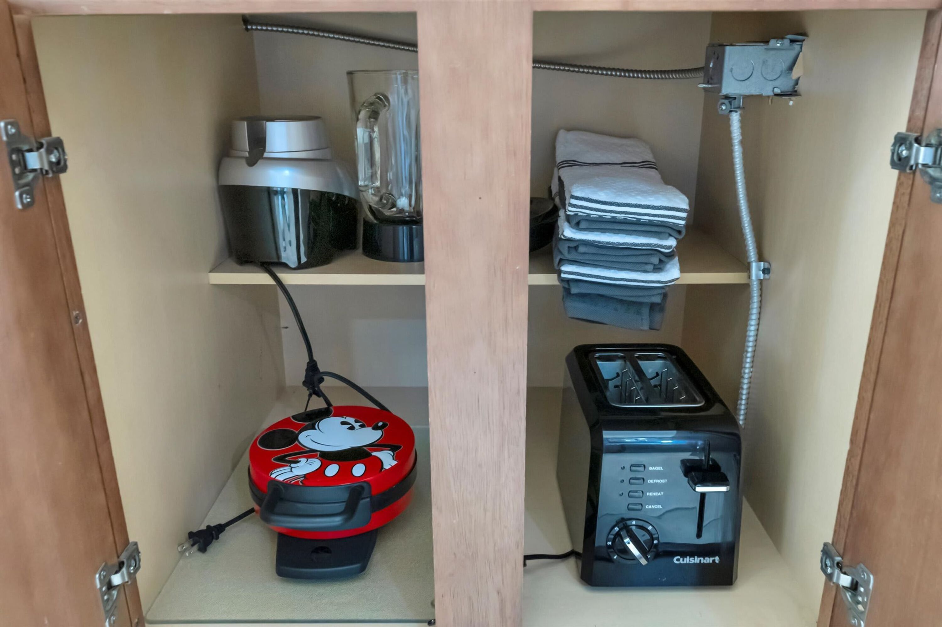Une cuisine équipée d’un grille-pain, d’un mixeur, d’une bouilloire et d’un four à micro-ondes, le tout posé sur le plan de travail.