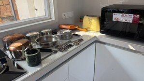 Una cocina con horno de convección, varias ollas y sartenes, y utensilios sobre la encimera.