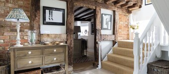 A charming Grade II listed holiday home in Petworth, recently remodelled with original beams, 3 bedrooms, 2 bathrooms a modern kitchen, cosy living space, and a large garden with pergola seating.