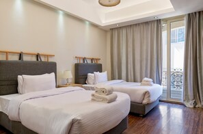 Ein Hotelzimmer mit zwei Betten, einem Balkon und einem modernen Deckenstil.