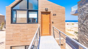 Un bâtiment moderne avec une porte en bois portant l’inscription « 4H » et une grande fenêtre.