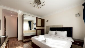 A hotel room with a large bed, a bedside table, a mirror, and a wardrobe. - Vesta - Luxury APT - 3BR - Mohandessin II (Giza)