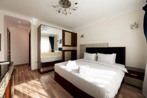 A hotel room with a large bed, a bedside table, a mirror, and a wardrobe. - Vesta - Luxury APT - 3BR - Mohandessin II (Giza)
