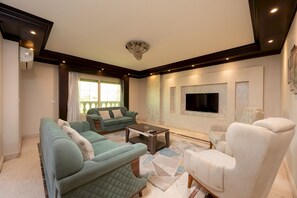 A living room with a sofa set, a coffee table, and a TV mounted on the wall. - Vesta - Luxury APT - 3BR - Mohandessin II (Giza)