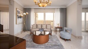 A spacious living room with a large sofa, a coffee table, and a chandelier. - Vesta- Luxury Panoramic Duplex - 3br- Zamalek II (Cairo)