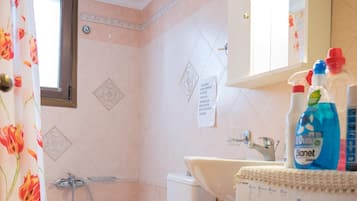 Un baño con inodoro, lavamanos y lavadora.