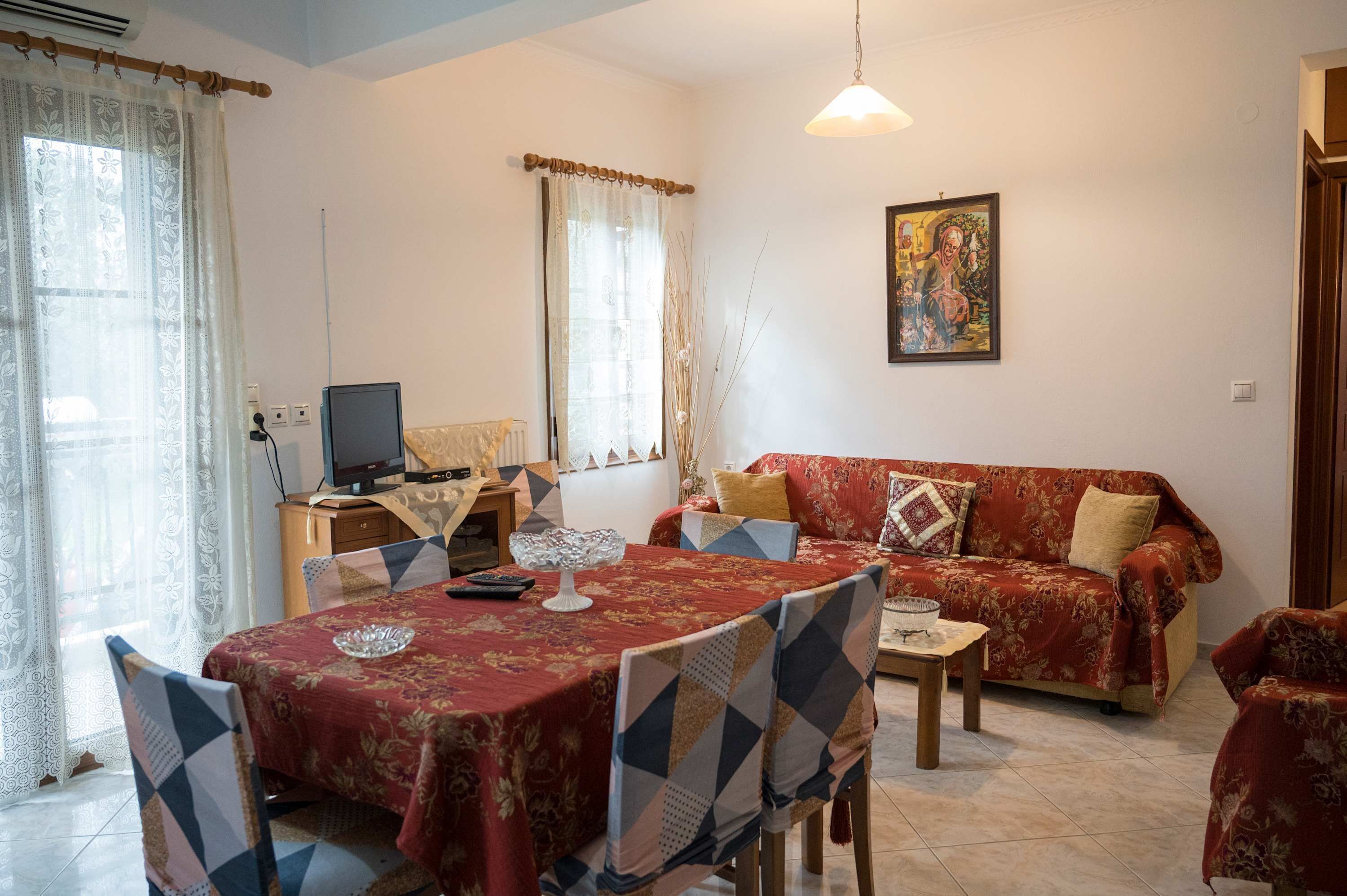 Een woonkamer met een eettafel, bank en televisie.