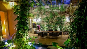 Un jardin intérieur comprenant un espace repas, un élément décoratif aquatique et un escalier.