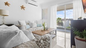 Ein modernes Wohnzimmer mit Sofa, Couchtisch und Blick ins Freie.