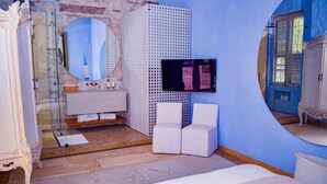 A bedroom with a bed, a white vanity, a mirror, and a window with shutters. - NOK Bright Suite In Ciudad Amurallada (Cartagena)