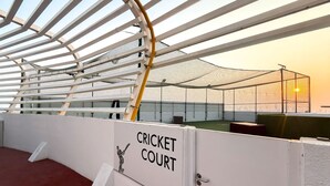 En cricketplan med ett nät runt om och en skylt som anger dess användningsområde.