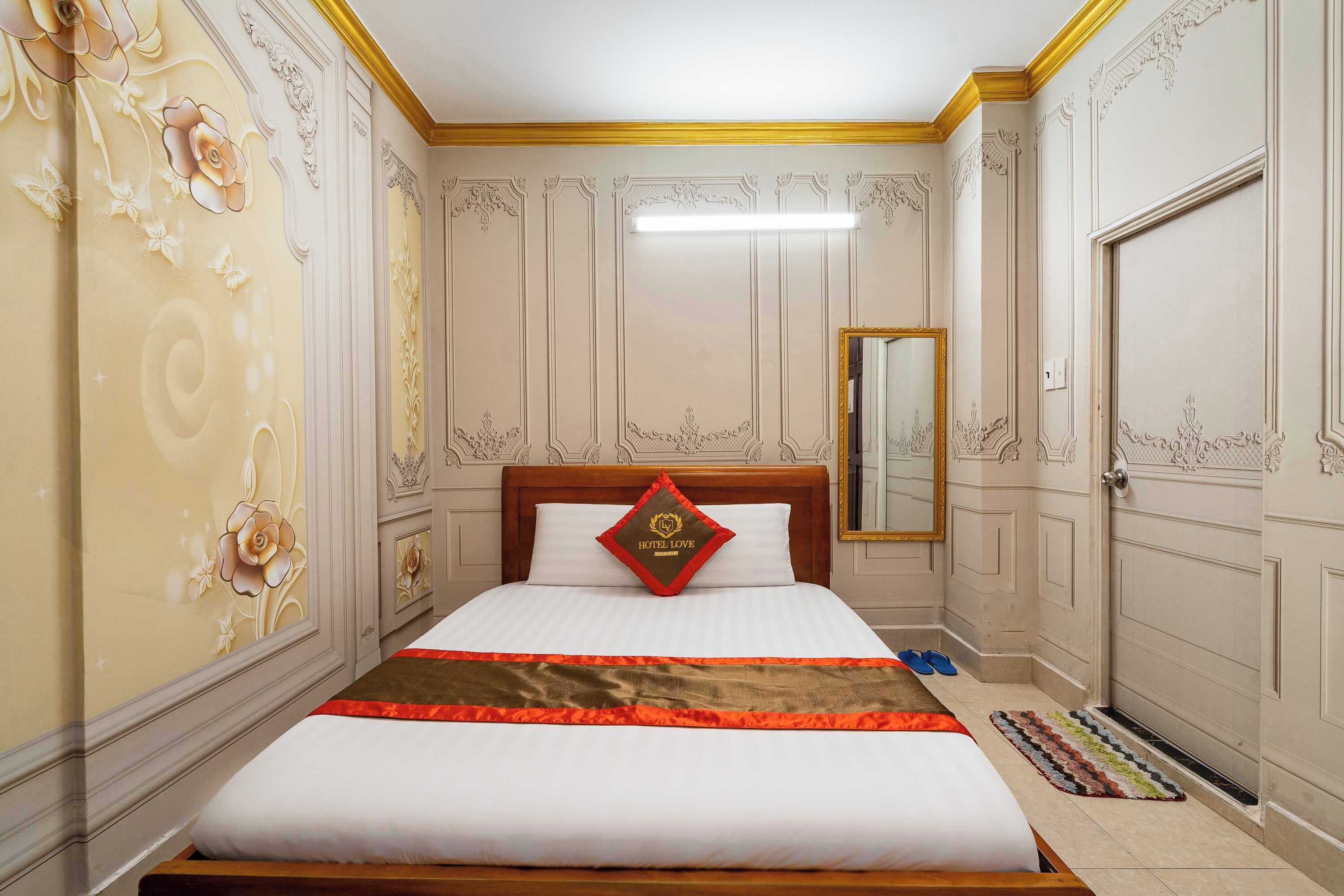 Een hotelkamer met een groot bed, een spiegel en een deur.