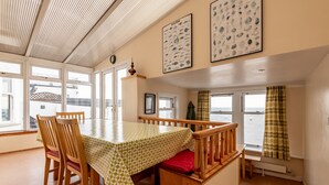A dining area with a table and chairs, large windows, and a view of the sea. - Appleton House | Lower Largo (Lower Largo)