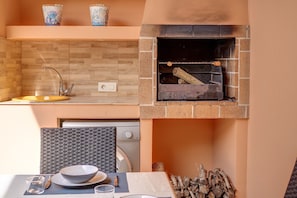 Cozinha com forno embutido, pia e área de jantar com mesa posta para dois.