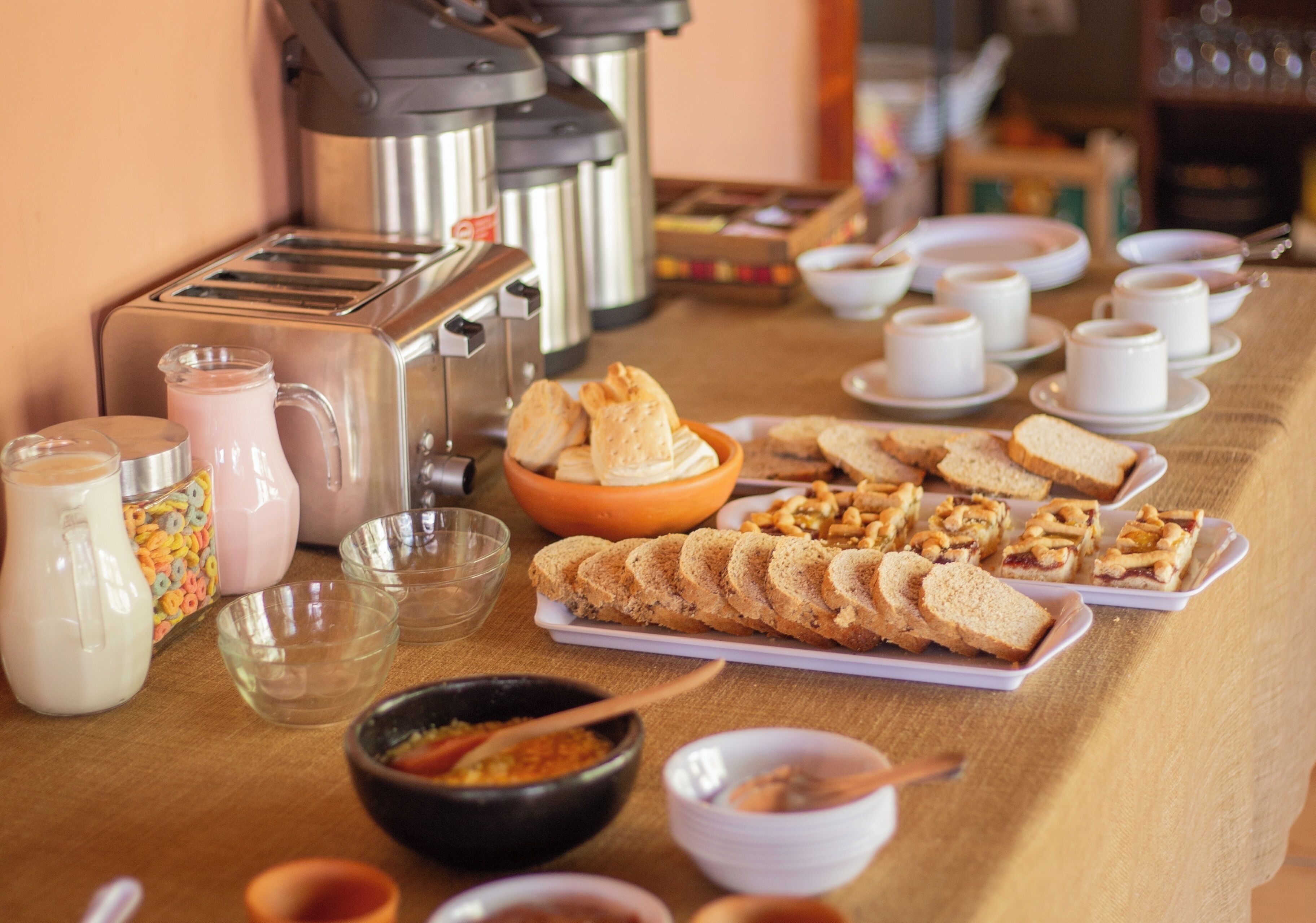 Un buffet de petit-déjeuner proposant une variété d’aliments, notamment du pain, des viennoiseries et des boissons.