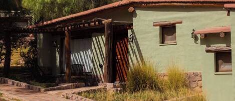 A rustic building with a stone pathway leading to a wooden door.