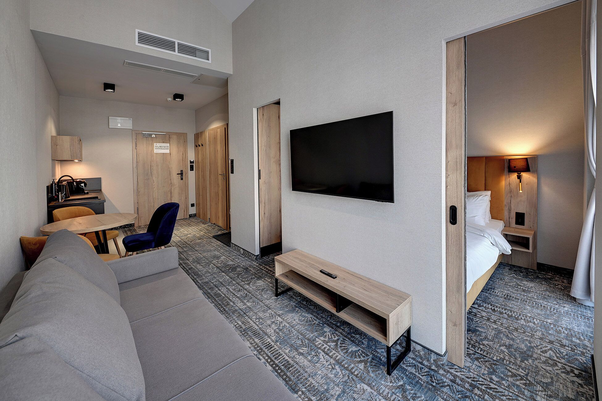 Et moderne hotelværelse med sofa, fjernsyn og seng.