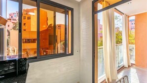 Un apartamento moderno con ventanas amplias, un balcón y una kitchenette.