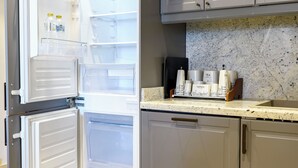 A kitchen with a double-door refrigerator, a marble backsplash, and a coffee maker on the counter. - Vesta - Luxury Apt- 1br- Aeon Tower (6th of October City)