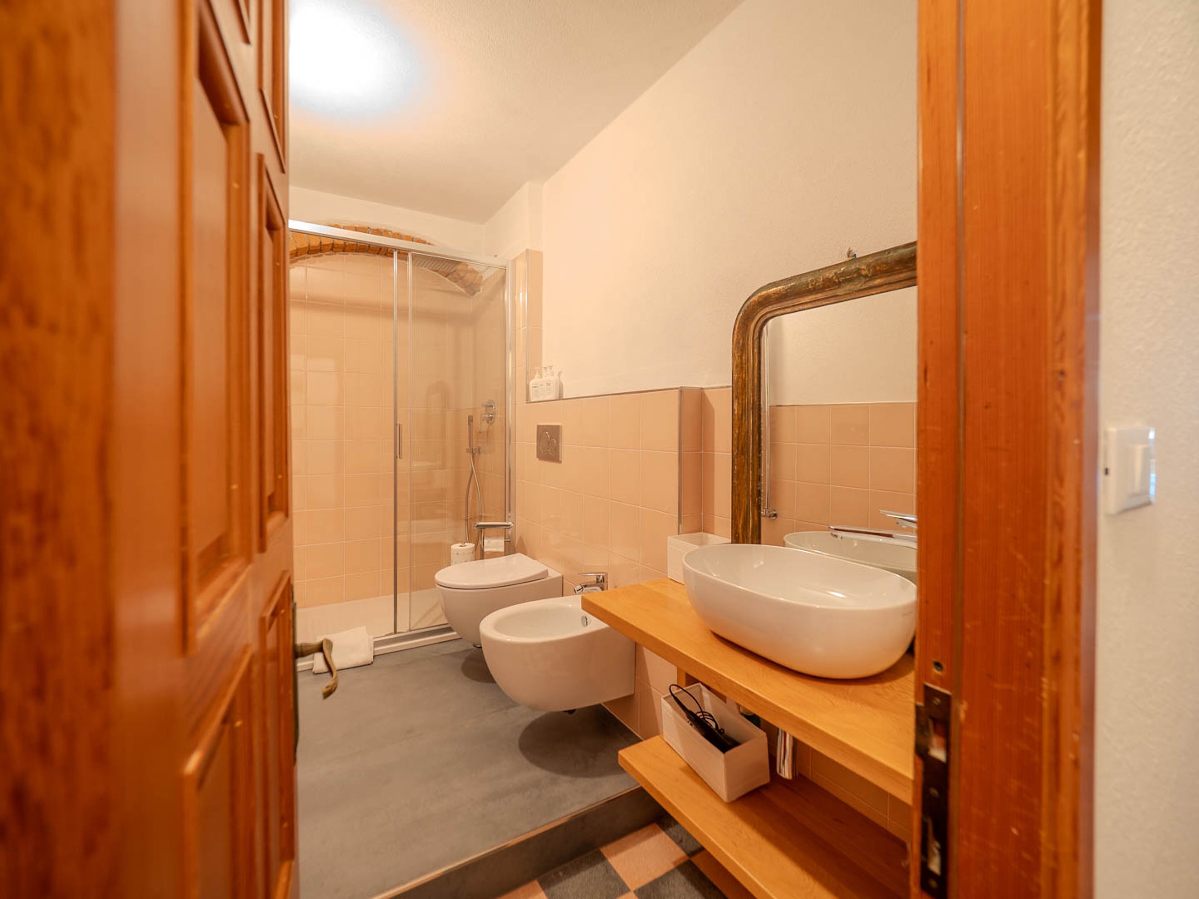 Une salle de bain moderne avec une douche à parois de verre, un lavabo blanc et un grand miroir.