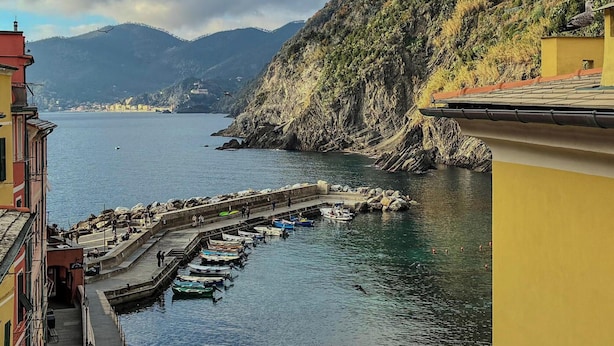 A coastal town with a marina, buildings along the waterfront, and mountains in the background. - Gemma Apartment with AC Sea View Balcony (Vernazza)