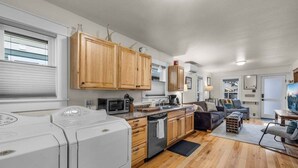 A modern kitchen with wooden cabinets, a built-in microwave, and a large window. - Bluebird Day - Pine Rosa Retreat, Cozy 2 BR, West side! (Bend)