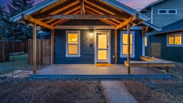 A house with a covered porch, a front door, and a small deck. - Bluebird Day - Pine Rosa Retreat, Cozy 2 BR, West side! (Bend)