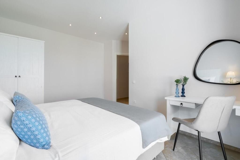 A bedroom with a bed, a desk, and a chair.