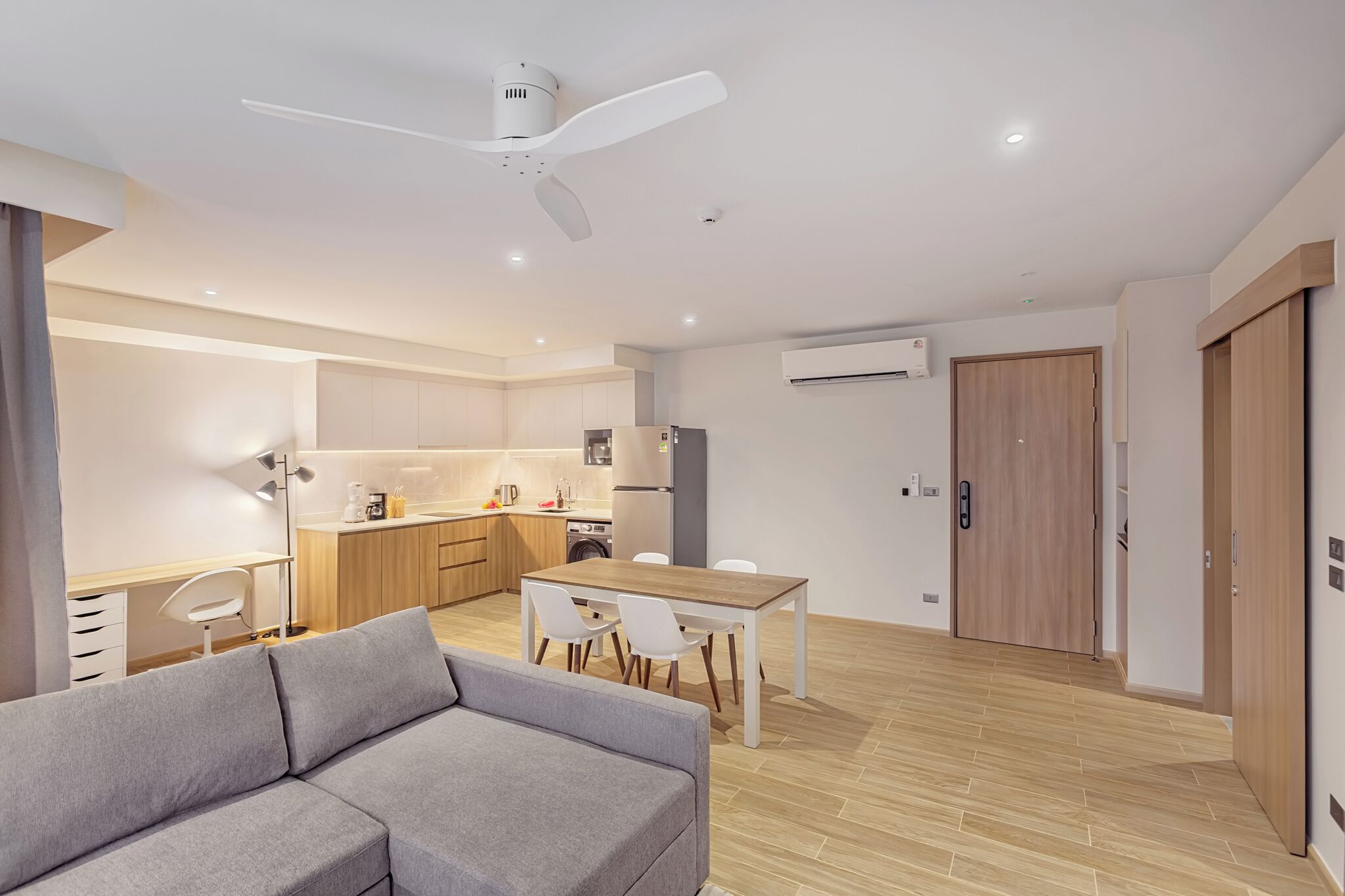 A modern apartment with a kitchenette, dining area, and a living space with a sofa.
