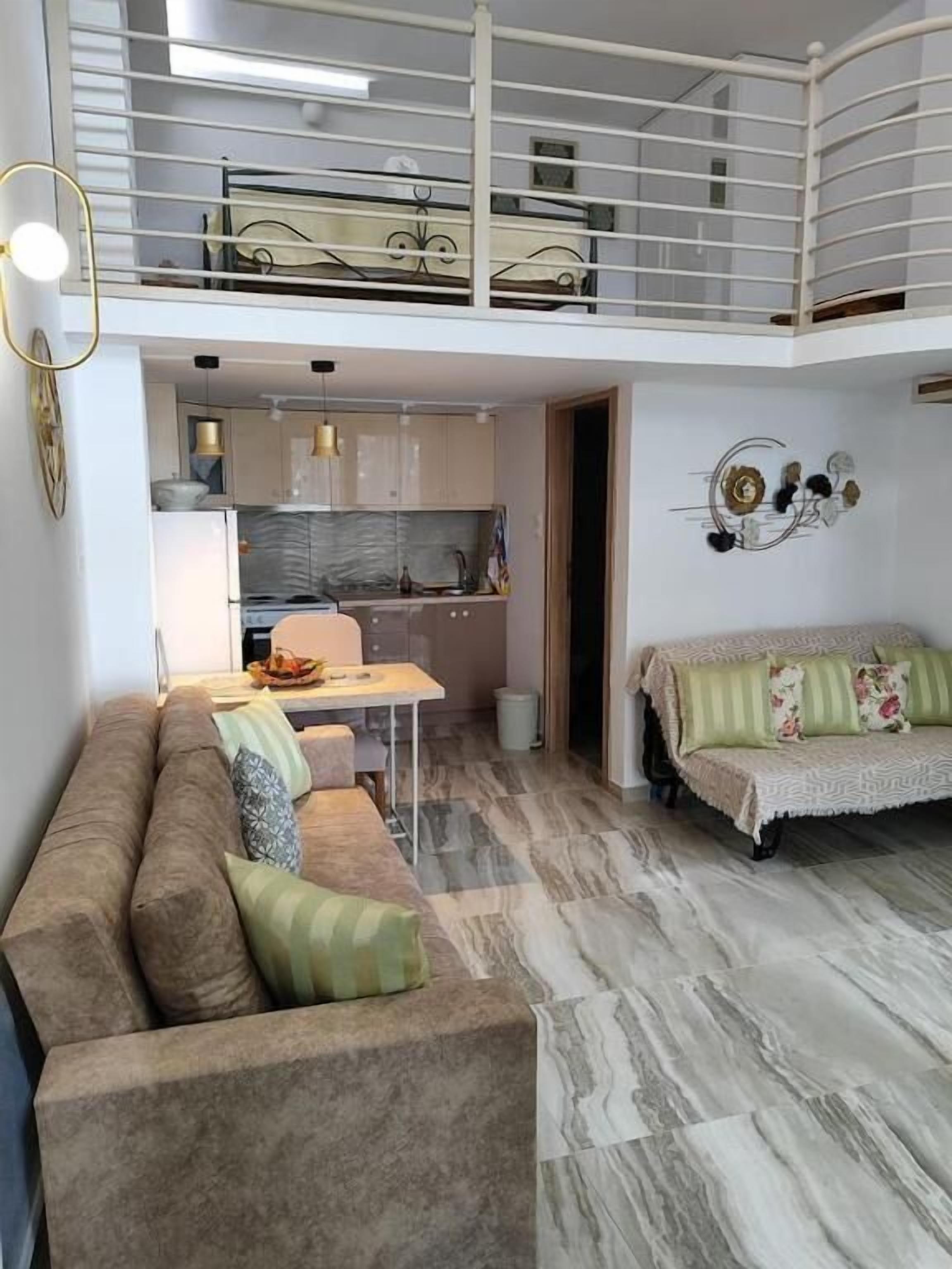 Een modern appartement met een zithoek, keuken en balkon.