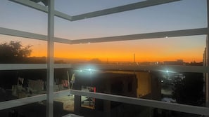 A multi-level building with balconies, a sunset view, and a clear sky. - Charming 2-bedroom Apartment With Stunning Views in Santiago (Santiago de los Caballeros)