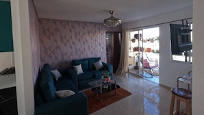 A modern living room with a sofa, a coffee table, and a TV. - Charming 2-bedroom Apartment With Stunning Views in Santiago (Santiago de los Caballeros)