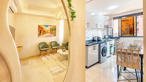 Une cuisine moderne équipée d’un lave-linge, d’un coin repas avec des chaises et d’un tableau accroché au mur.