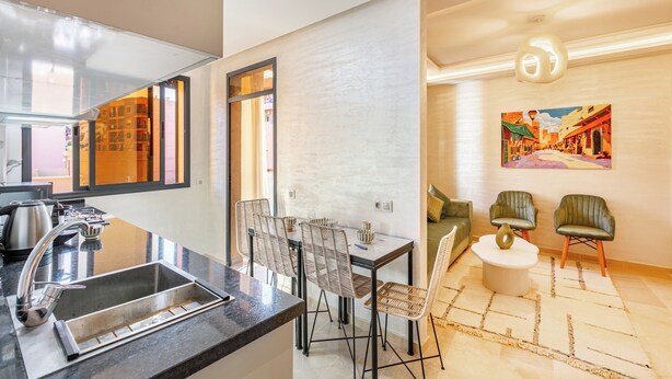 Une cuisine moderne dotée d’un évier encastré et d’un coin repas avec une table et des chaises.