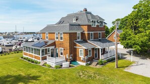 Et stort murstenshus med en bred veranda, garage og en bådebøje.