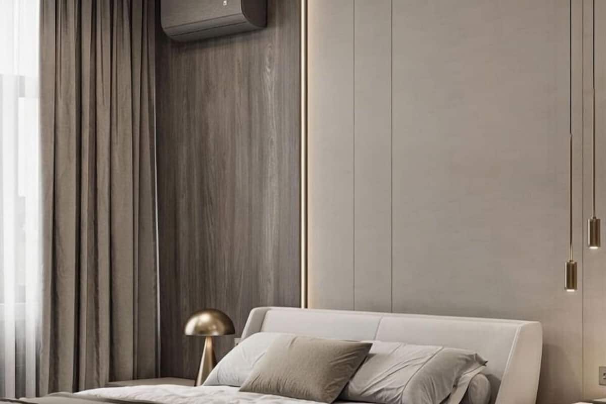 A modern bedroom with a large bed, a bedside lamp, and a built-in air conditioning unit.