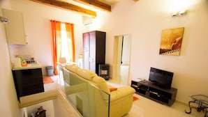 A modern living room with a sofa, TV, and a painting on the wall. - Valletta-Central duplex maisonette (Valletta)