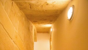 A stone staircase leading upwards, with a light fixture at the top. - Valletta-Central duplex maisonette (Valletta)