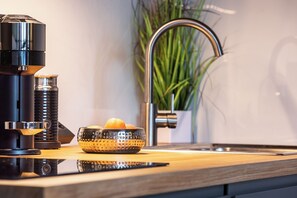 A kitchen with a coffee maker, a bowl of fruit, and a plant. - MyWinkl-Design-Ferienwohnungen  (Reit im Winkl)