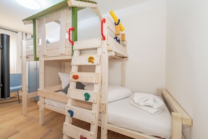 A bunk bed with a wooden ladder and a small playhouse attached to the top. - MyWinkl-Design-Ferienwohnungen  (Reit im Winkl)