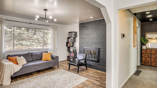 A modern living room with a gray sofa, a fireplace, and a bookshelf. - 3 Mi to Geha Field at Arrowhead: Easy Match Access (Independence)