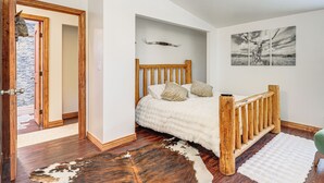 A bedroom with a wooden bed, a white rug, and a cowhide rug on the floor. - Newly Renovated, Modern Mtn Getaway: Pets Welcome! (Vail)